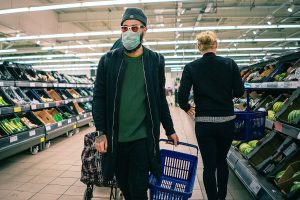 Man shopping in supermarket wearing a mask