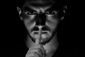 black and white photo, man with finger to lips. secret