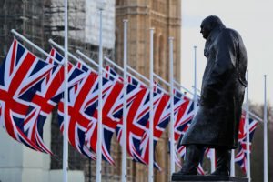 statue of CHurchill in front of Westminster with Union flags