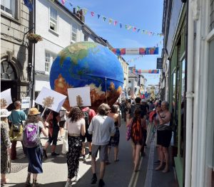 Giant globe centrepiece of climate change protest in Falmouth showing world on fire or flooded