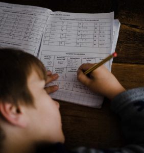 young pupil completing exam paper