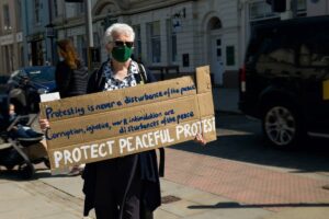 woman holding up peaceful protest placard
