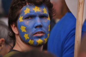 young man face painted with EU flag